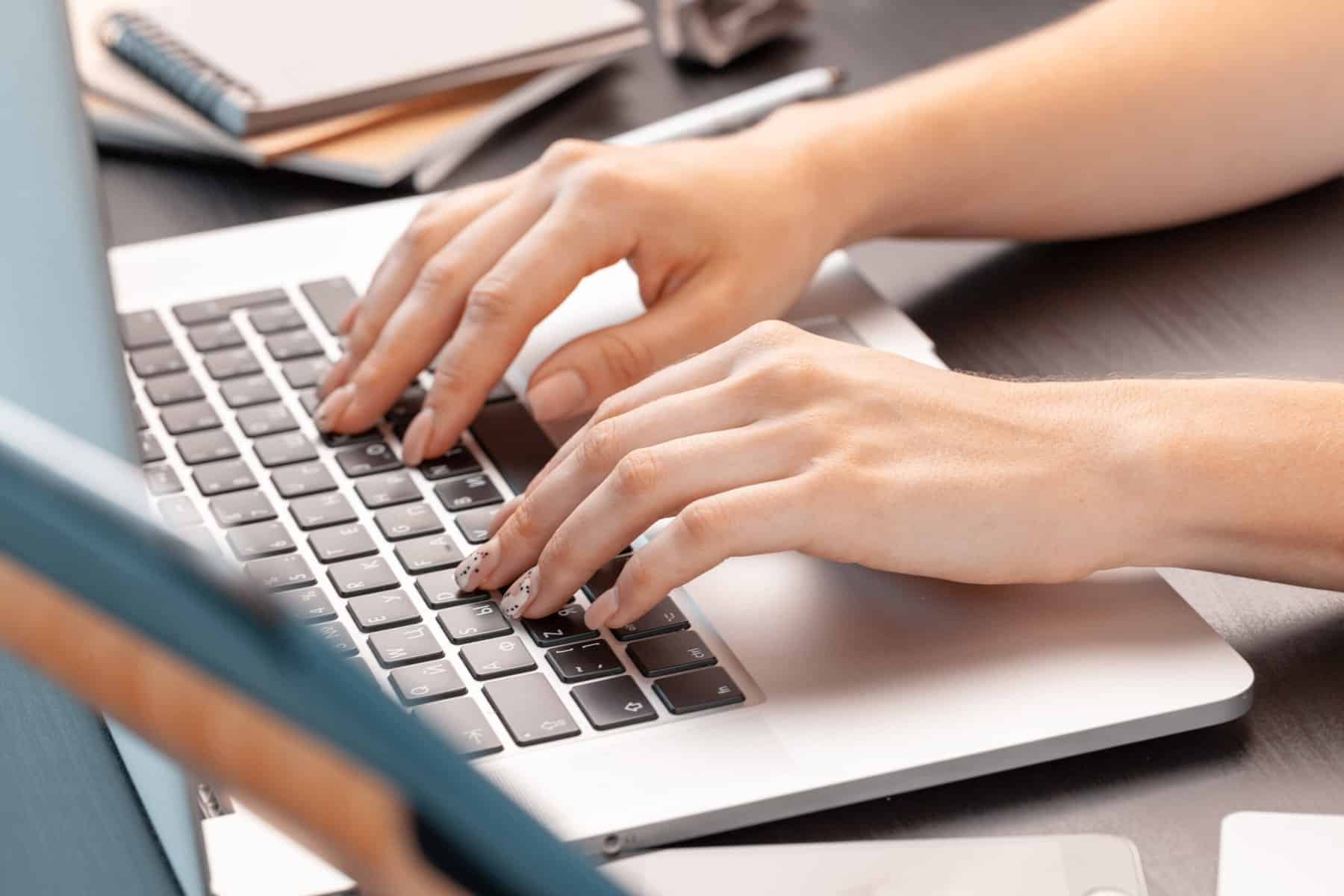 Close up of a female hands of woman office worker typing on the keyboard